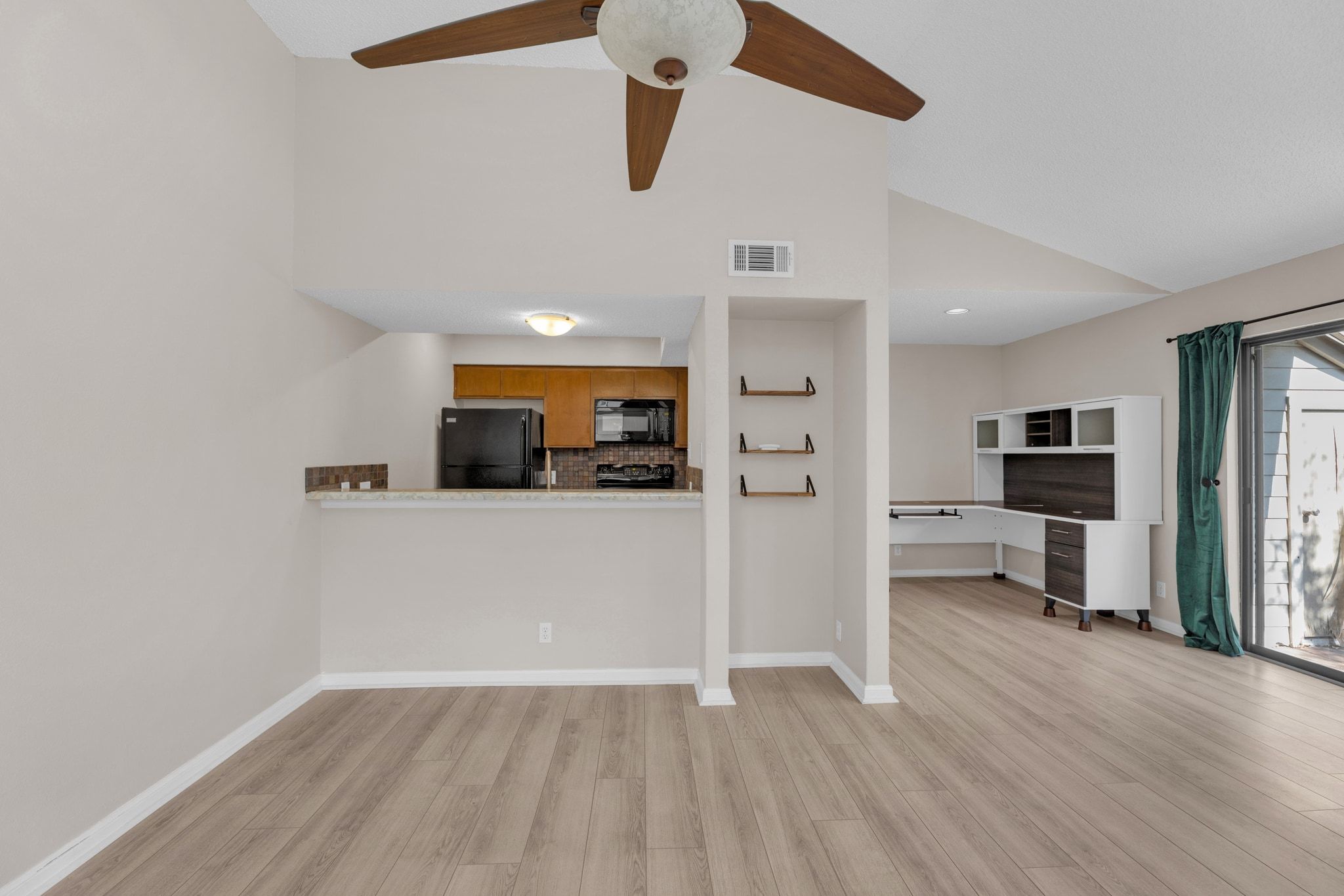 9226 Jollyville Road, Unit 280 Austin, TX 78759 - Photo 11 of 26 Expansive view of the living and dining area showing the open layout, high ceilings, and seamless flow into the kitchen, creating an inviting space for relaxing or hosting friends.