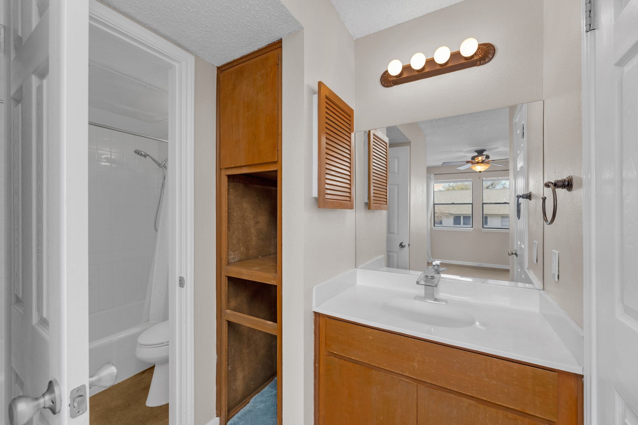 9226 Jollyville Road, Unit 280 Austin, TX 78759 - Photo 19 of 26 Modern vanity with sleek countertop and updated faucet, complemented by warm wood cabinetry and open shelving that adds character and extra storage.