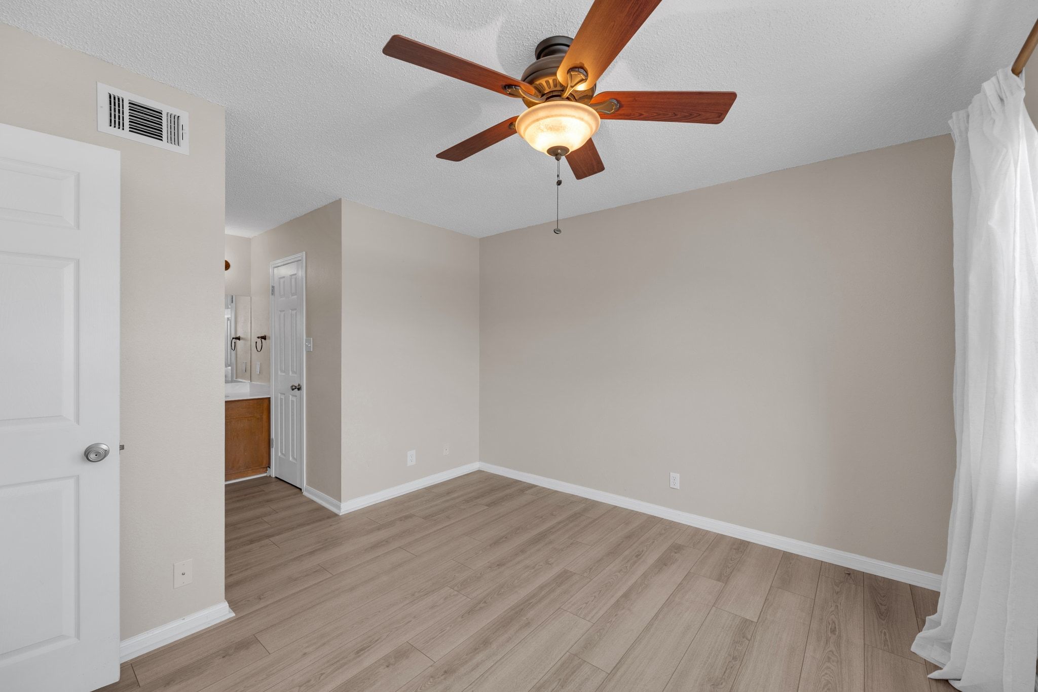 9226 Jollyville Road, Unit 280 Austin, TX 78759 - Photo 21 of 26 Spacious bedroom with vaulted ceilings, wood style flooring, and a ceiling fan for year round comfort. The neutral tones and natural light create a calm, airy retreat.