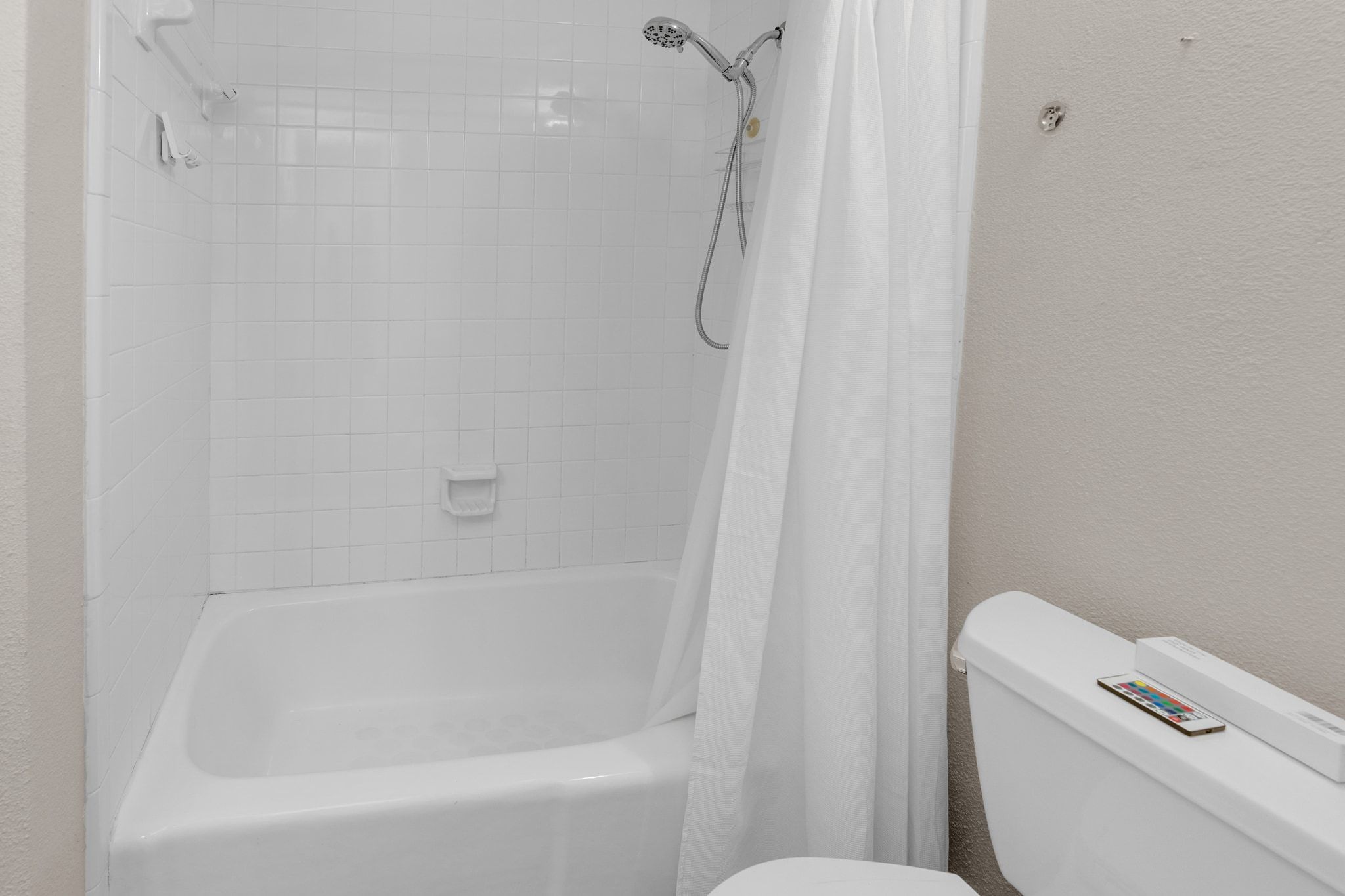 9226 Jollyville Road, Unit 280 Austin, TX 78759 - Photo 26 of 26 Clean and bright bathroom with classic white tile surround and full shower and tub combination, offering a simple and fresh space to start and end your day.