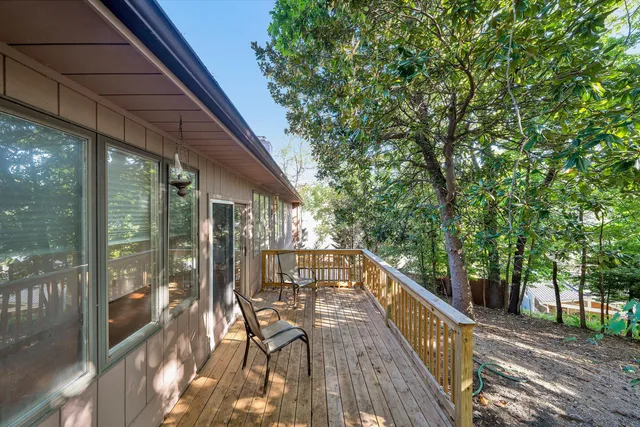 a balcony with wooden floor and outdoor seating