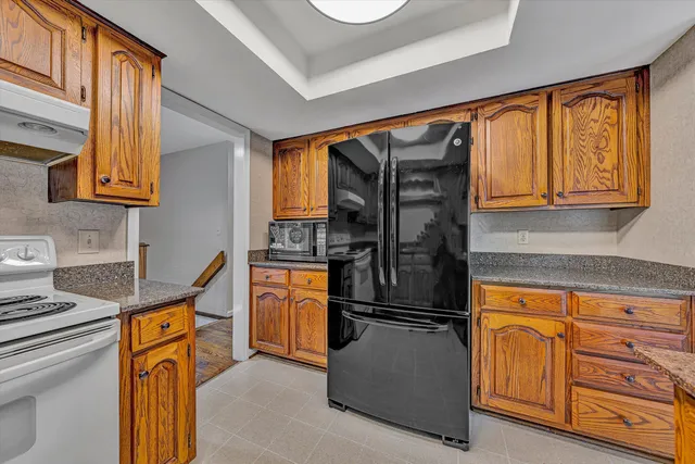 a kitchen with stainless steel appliances granite countertop a refrigerator and a stove top oven