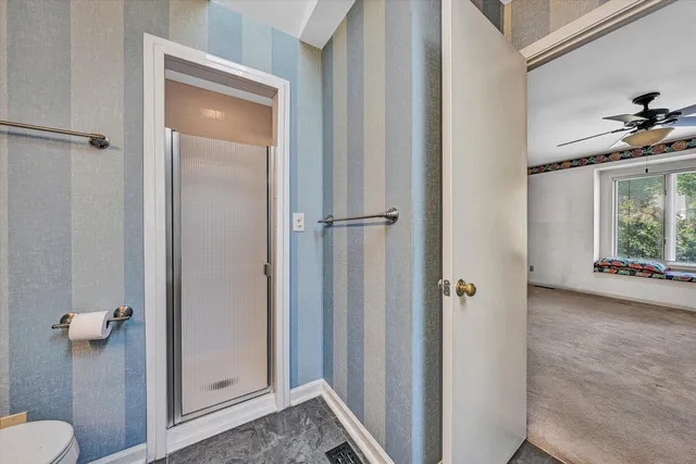 a view of bathroom with a shower and a toilet
