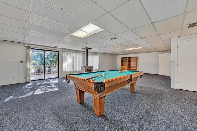 a room with pool table and windows