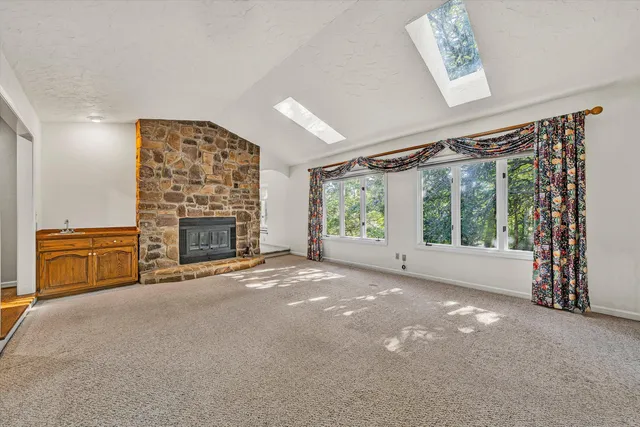 a view of an empty room with a fireplace and a window
