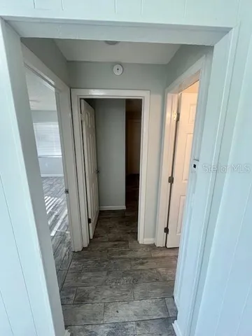 a view of a hallway with wooden floor and closet