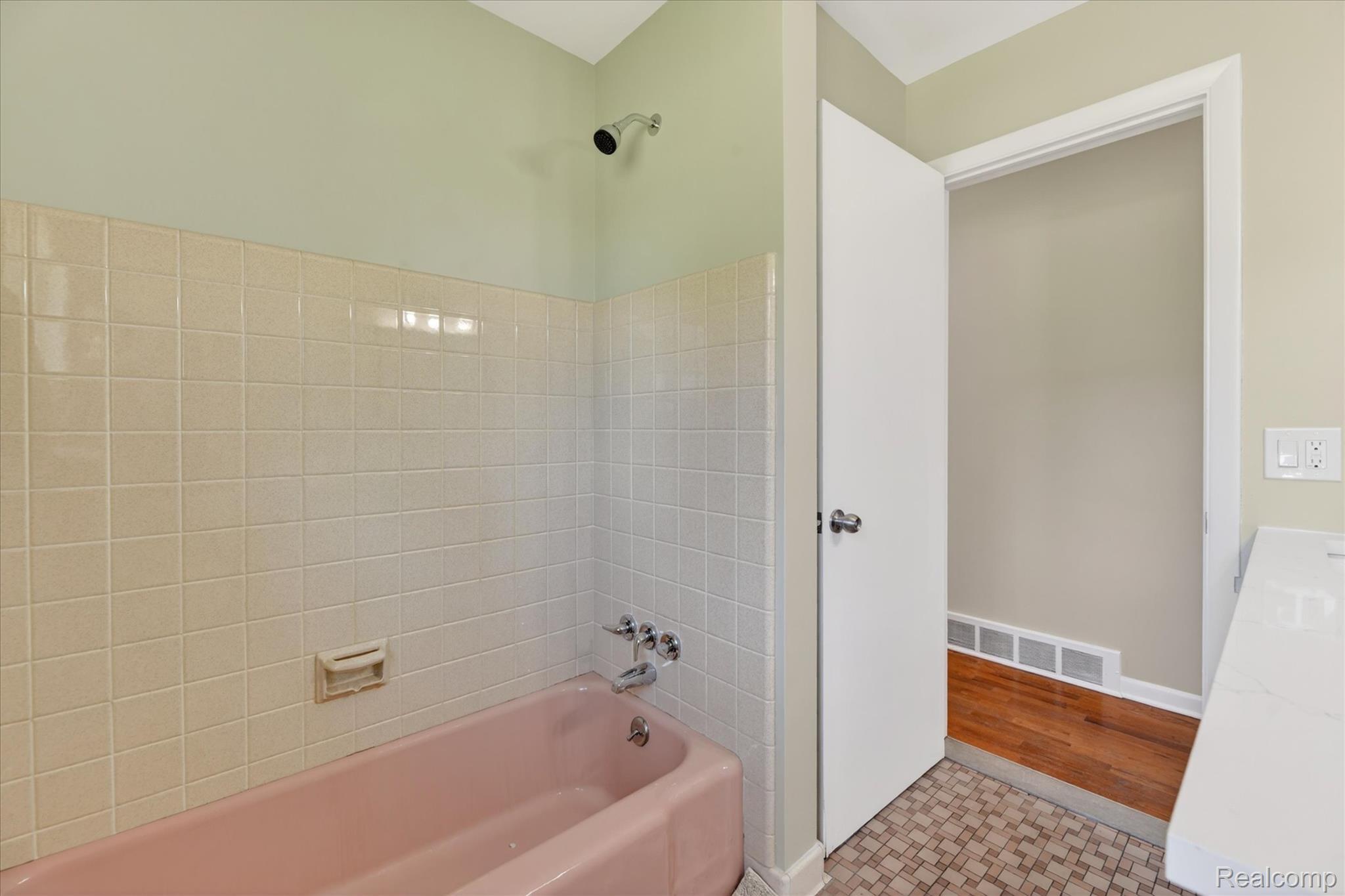 2250 Montague Road Davison, MI 48423 - Photo 27 of 45 Bathroom featuring a pink tub, white tiled surround, chrome showerhead, and patterned floor tiles