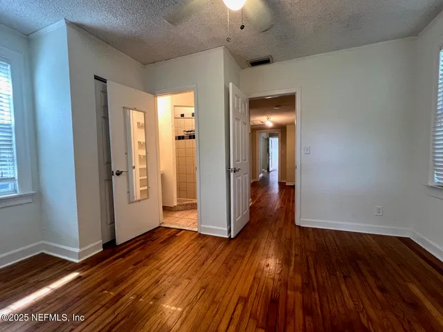 a view of a room with wooden floor and door