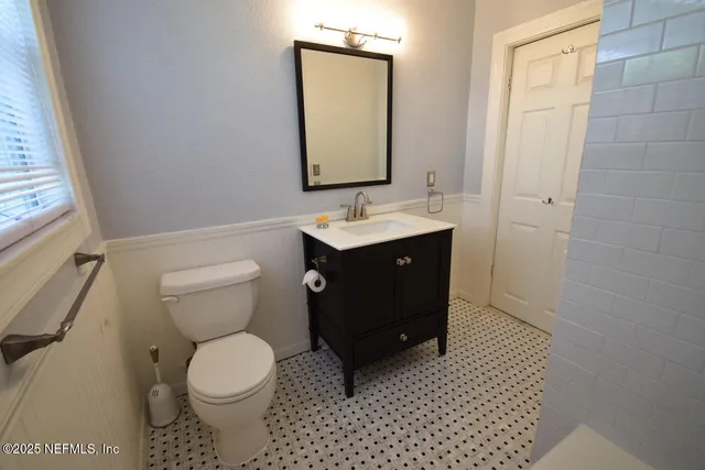 a bathroom with a toilet sink and mirror