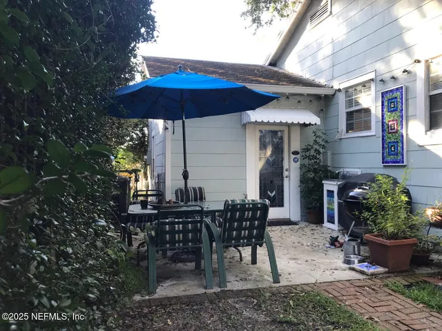 a view of a patio with a table and chairs under an umbrella