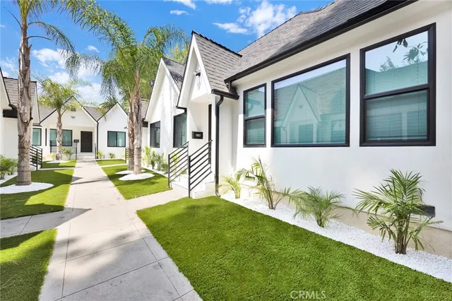 a front view of a house with a garden and plants