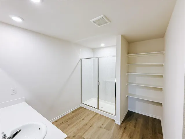 a view of an empty room and wooden floor