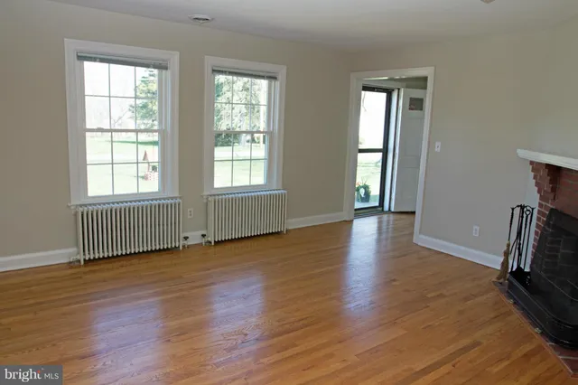 an empty room with wooden floor and a window