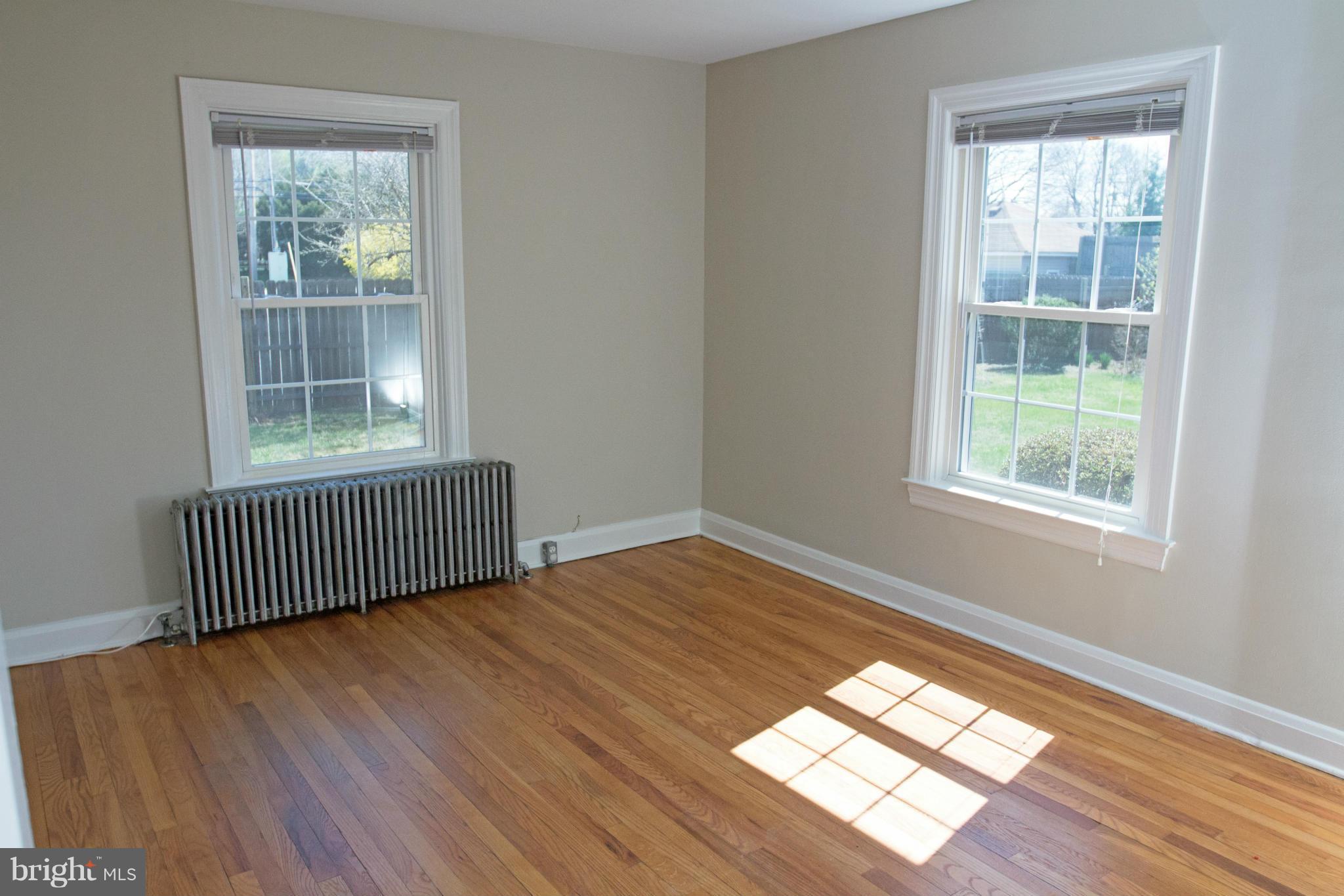 5303 Glen Falls Road Reisterstown, MD 21136 - Photo 8 of 30 an empty room with wooden floor and windows