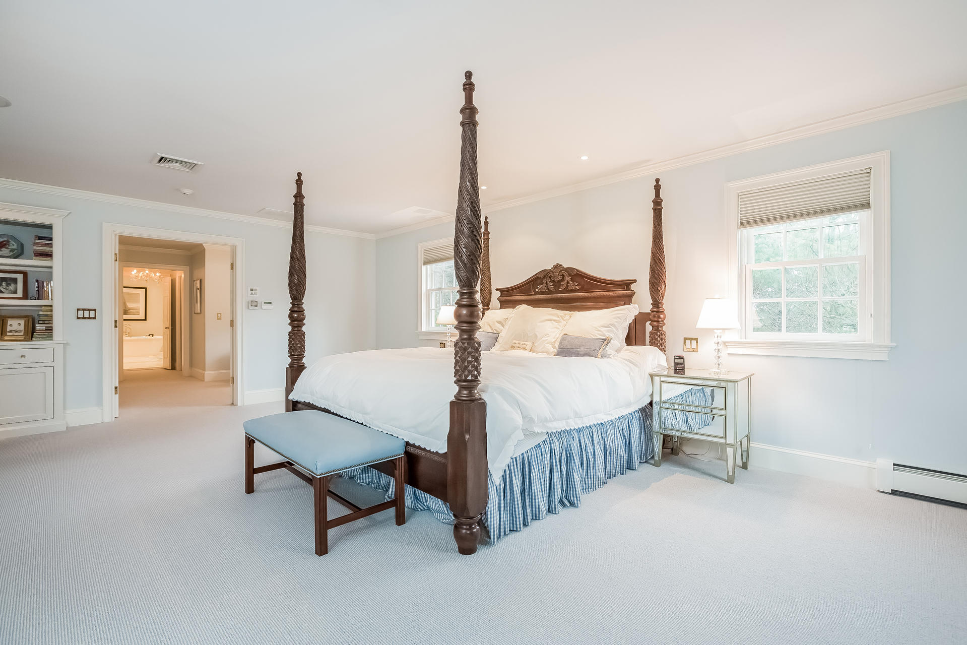 94 Marshall Ridge Road New Canaan, CT 06840 - Photo 19 of 50 a spacious bedroom with a bed a table and windows