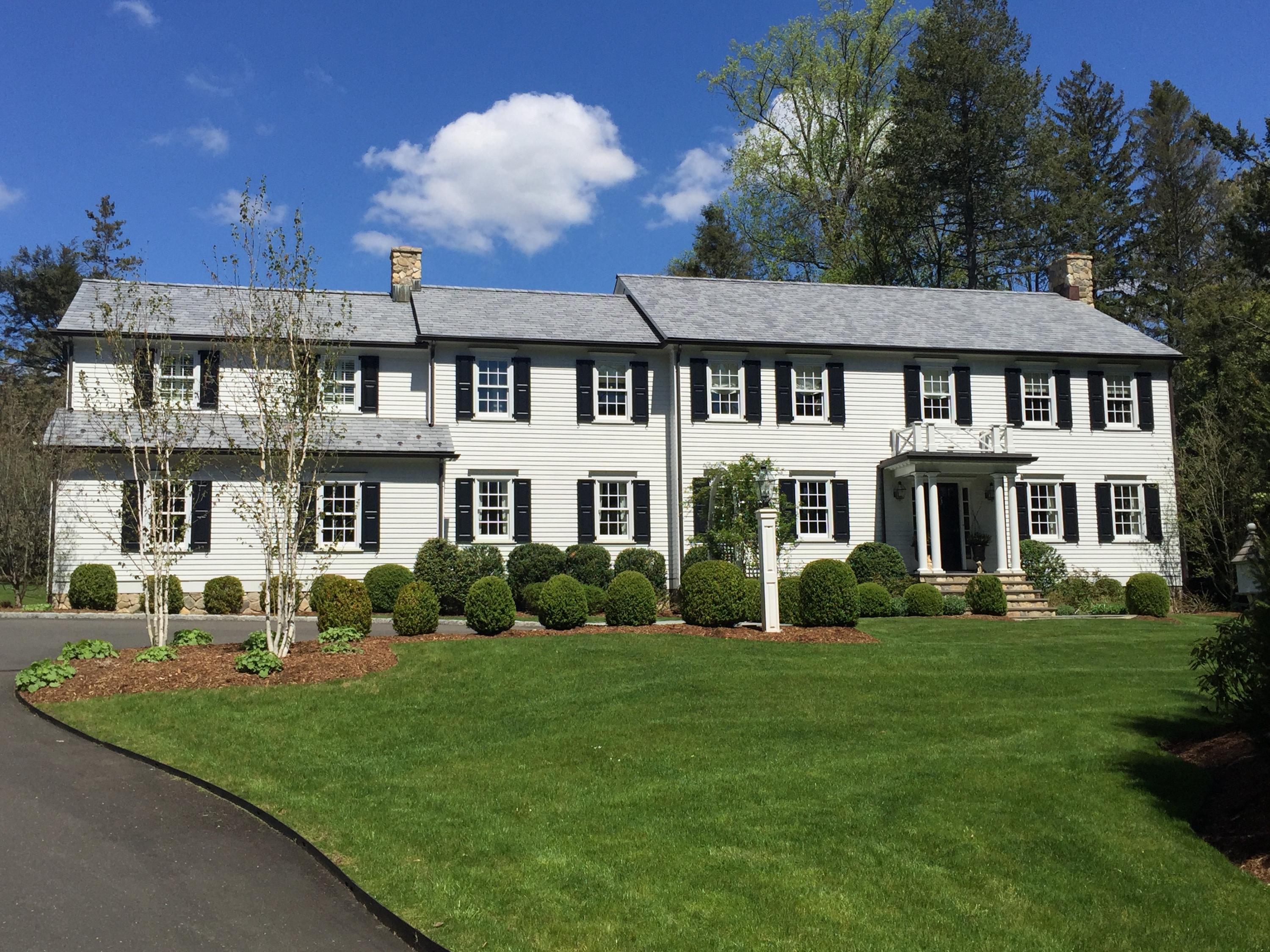 94 Marshall Ridge Road New Canaan, CT 06840 - Photo 3 of 50 a front view of a house with a yard table and chairs
