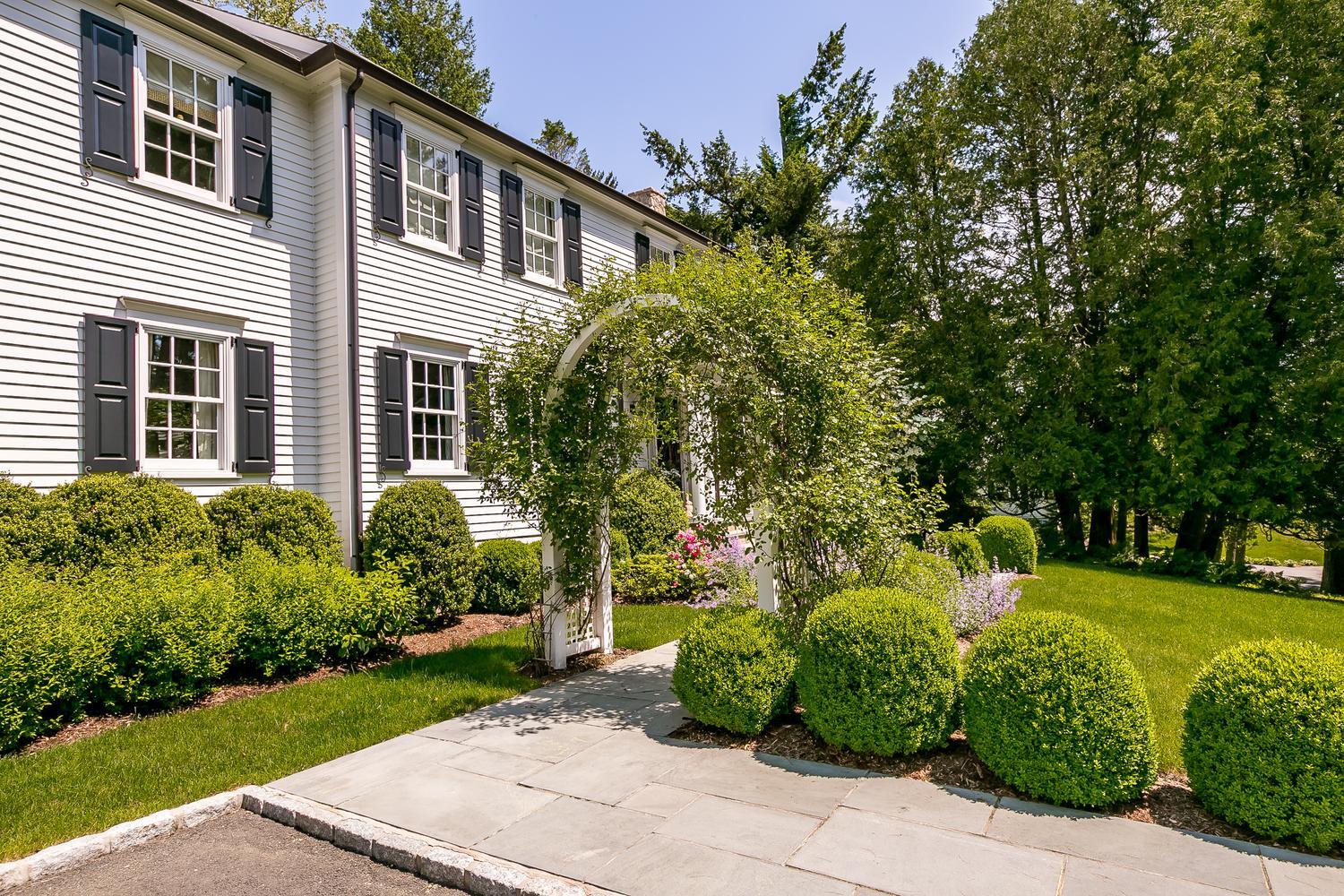 94 Marshall Ridge Road New Canaan, CT 06840 - Photo 4 of 50 a front view of a house with a garden