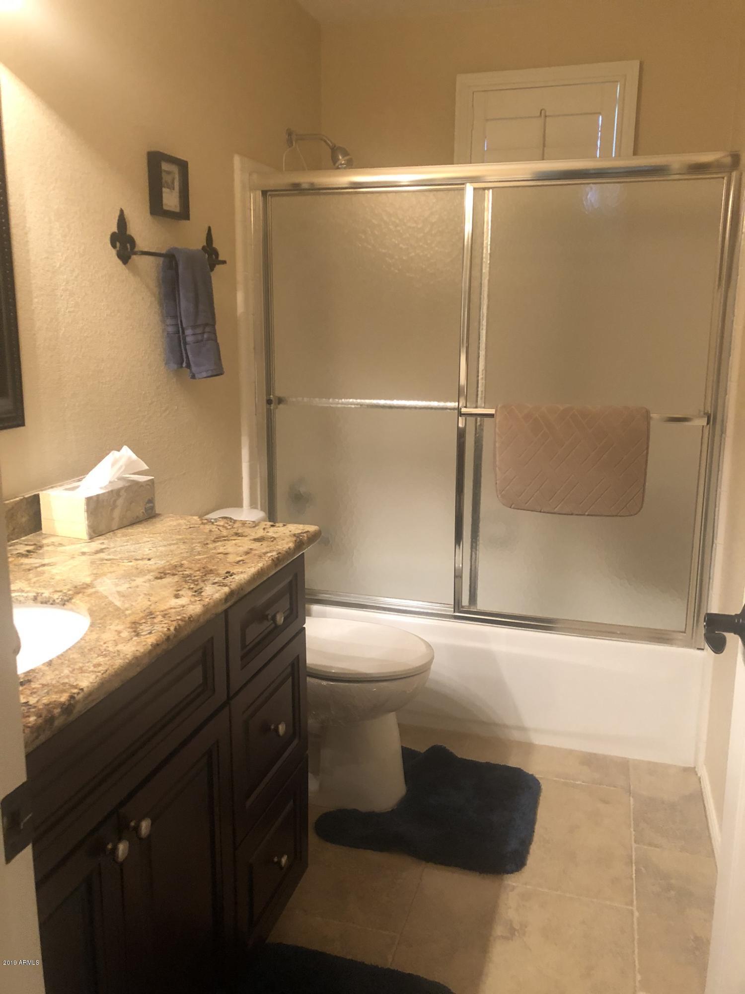 3923 North 151st Avenue Goodyear, AZ 85395 - Photo 12 of 22 a bathroom with a granite countertop sink toilet and shower