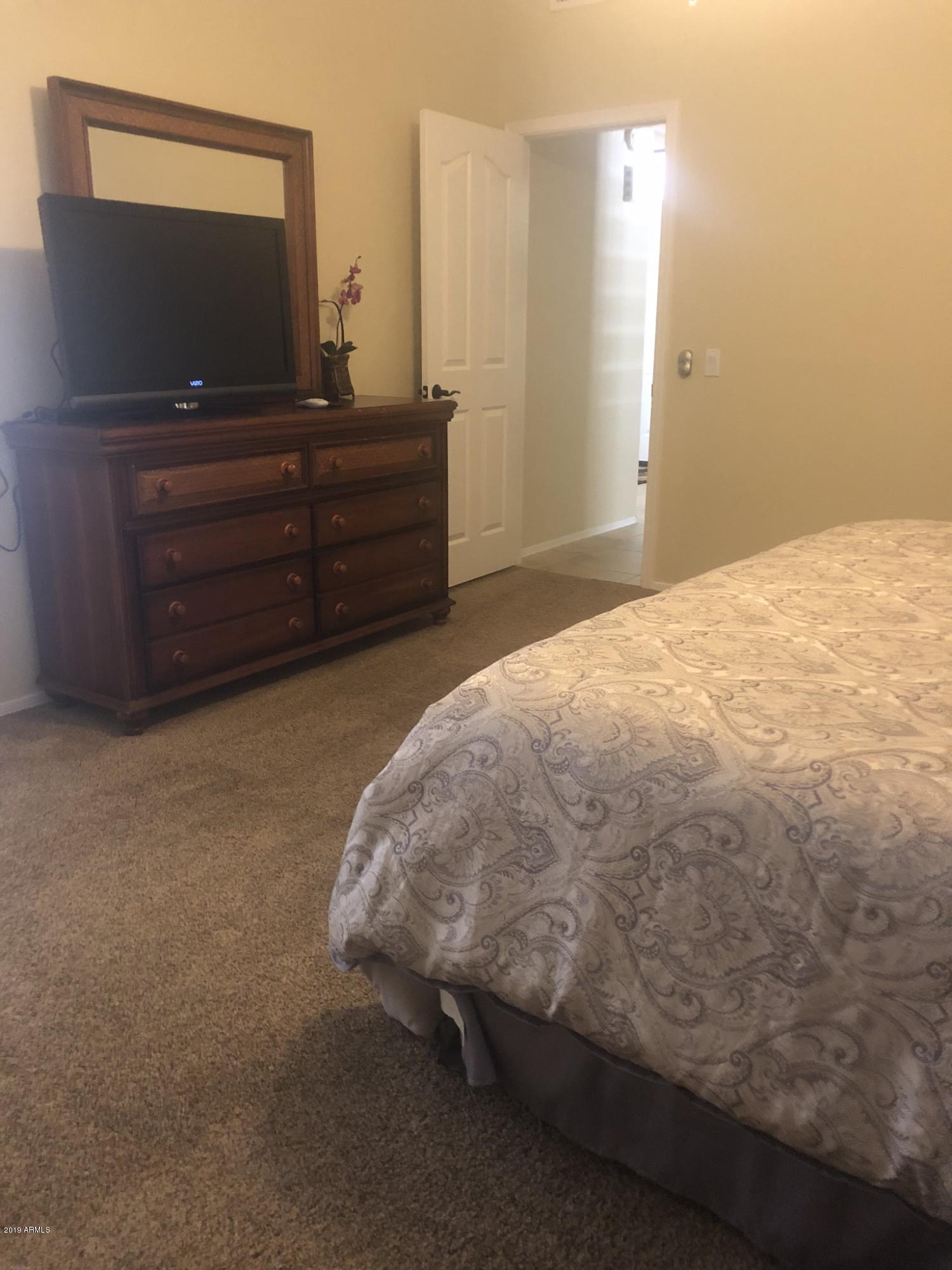 3923 North 151st Avenue Goodyear, AZ 85395 - Photo 15 of 22 a bed sitting in a spacious bedroom and a flat screen tv