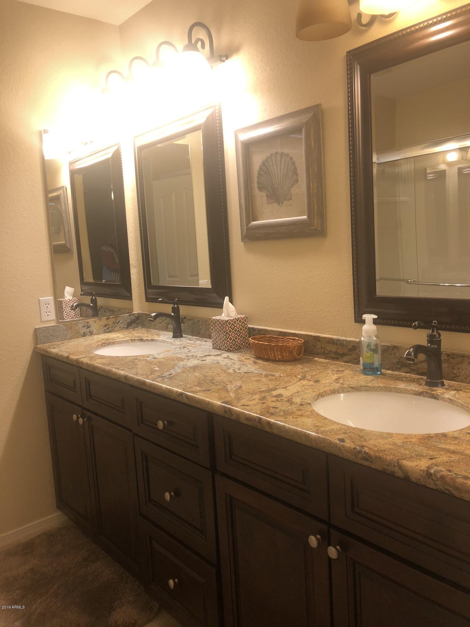 3923 North 151st Avenue Goodyear, AZ 85395 - Photo 16 of 22 a bathroom with a granite countertop double vanity sinks and a mirror