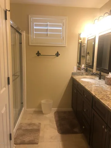 a bathroom with a granite countertop sink a toilet and shower