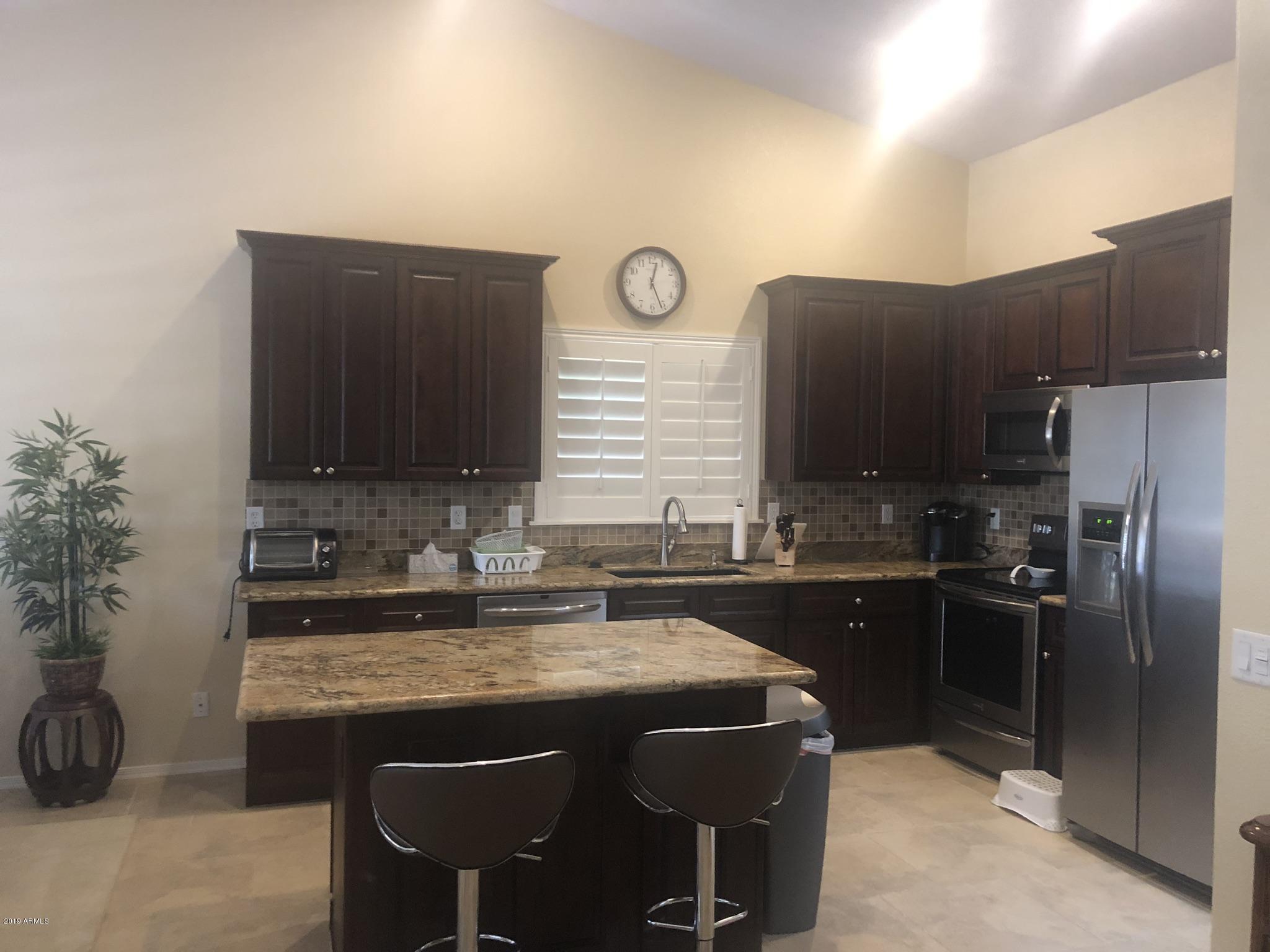 3923 North 151st Avenue Goodyear, AZ 85395 - Photo 3 of 22 a kitchen with a sink cabinets and stainless steel appliances