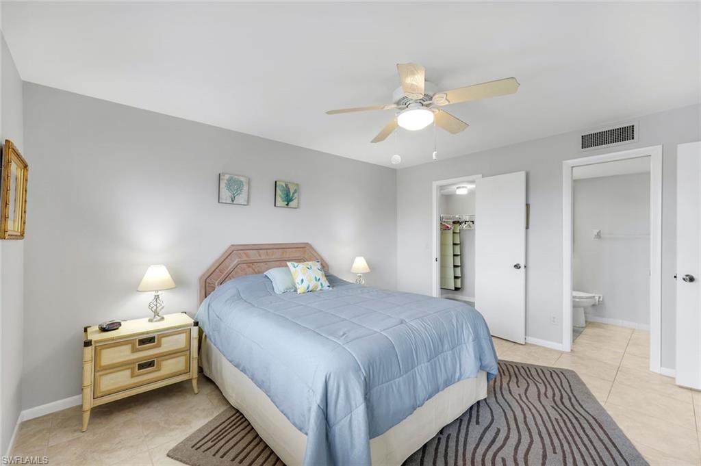 37 High Point Circle East, Unit 109 Naples, FL 34103 - Photo 11 of 37 a bedroom with a bed and a chandelier