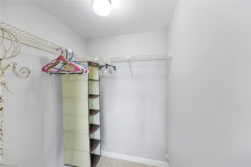 37 High Point Circle East, Unit 109 Naples, FL 34103 - Photo 12 of 37 a view of walk in closet with clothes and shoes