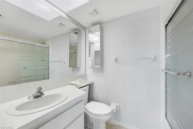 a bathroom with a toilet sink a mirror and vanity