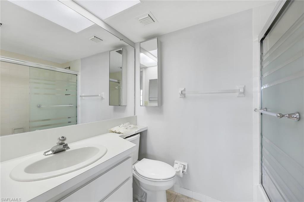 37 High Point Circle East, Unit 109 Naples, FL 34103 - Photo 15 of 37 a bathroom with a toilet sink a mirror and vanity