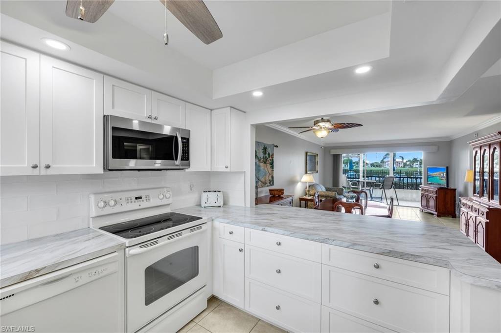 37 High Point Circle East, Unit 109 Naples, FL 34103 - Photo 2 of 37 a kitchen with stove a sink and cabinets