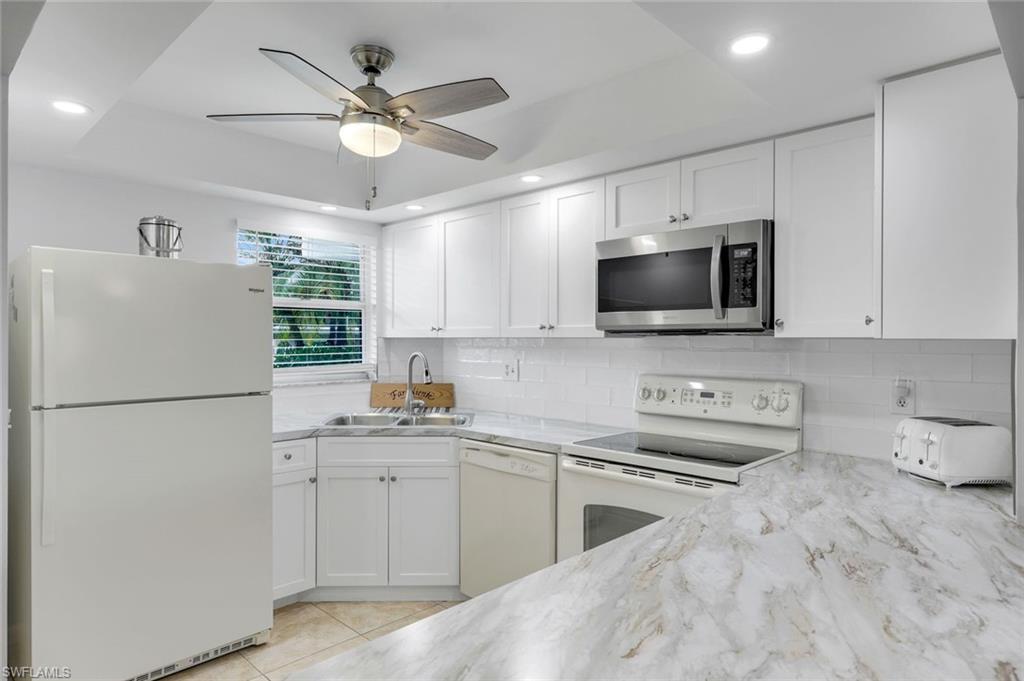 37 High Point Circle East, Unit 109 Naples, FL 34103 - Photo 3 of 37 a kitchen with a sink white cabinets and stainless steel appliances