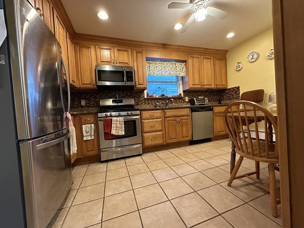 4 Glendale Place Everett, MA 02149 - Photo 2 of 14 a kitchen with stainless steel appliances granite countertop a stove top oven a sink a dining table and chairs