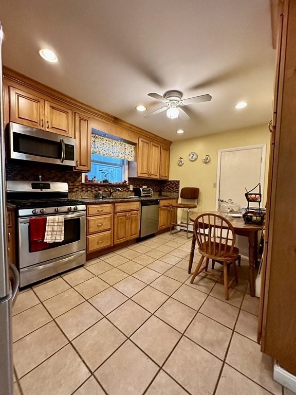 4 Glendale Place Everett, MA 02149 - Photo 3 of 14 a kitchen with stainless steel appliances kitchen island granite countertop a stove top oven a sink a dining table and chairs