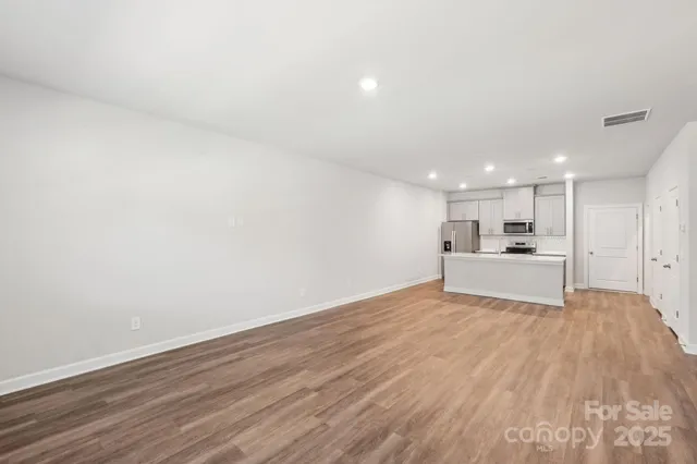 a view of a kitchen with wooden floor and a sink