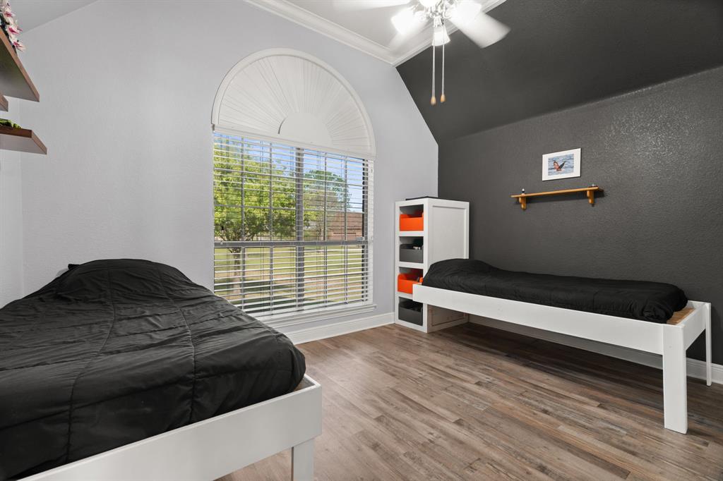 112 Waterfall Court Azle, TX 76020 - Photo 23 of 40 a bedroom with a bed and a chandelier