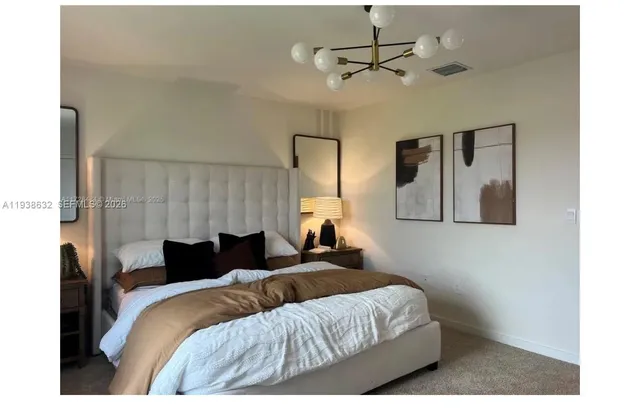 a bedroom with a bed and a chandelier
