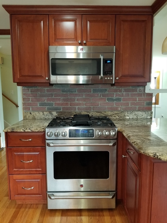225 Governors Road, Unit 225 Quincy, MA 02169 - Photo 5 of 19 a stove top oven sitting inside of a kitchen and granite counter tops