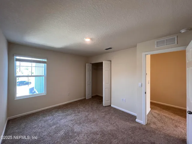 an empty room with windows and closet