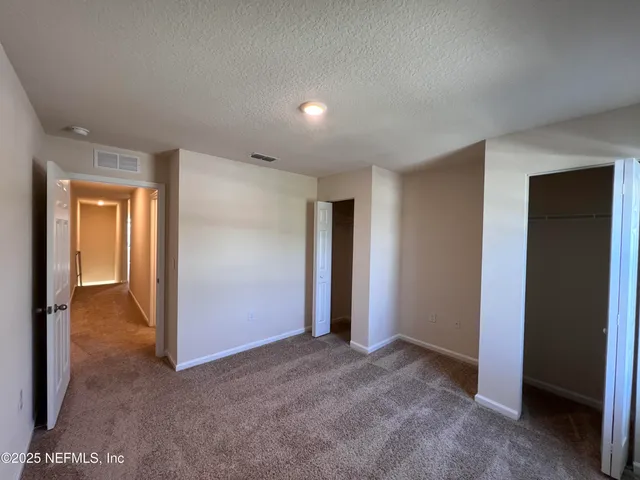 an empty room with closet and a bathroom