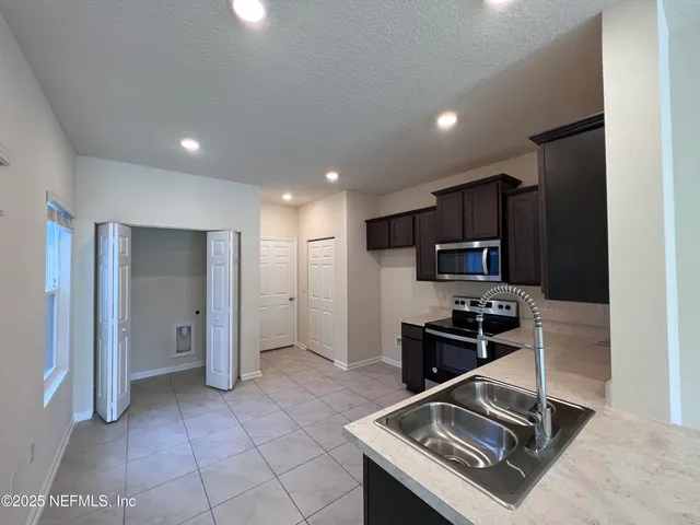 a kitchen with stainless steel appliances granite countertop a refrigerator and a stove top oven
