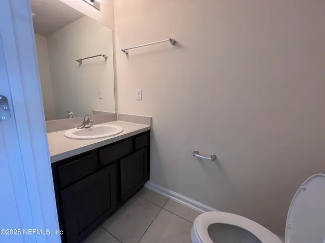 a bathroom with a sink vanity mirror and toilet