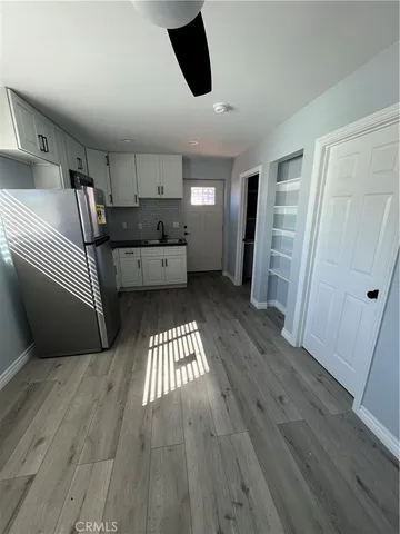 a kitchen with stainless steel appliances wooden floor and living room