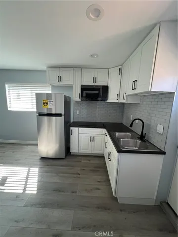 a kitchen with stainless steel appliances a refrigerator sink and microwave