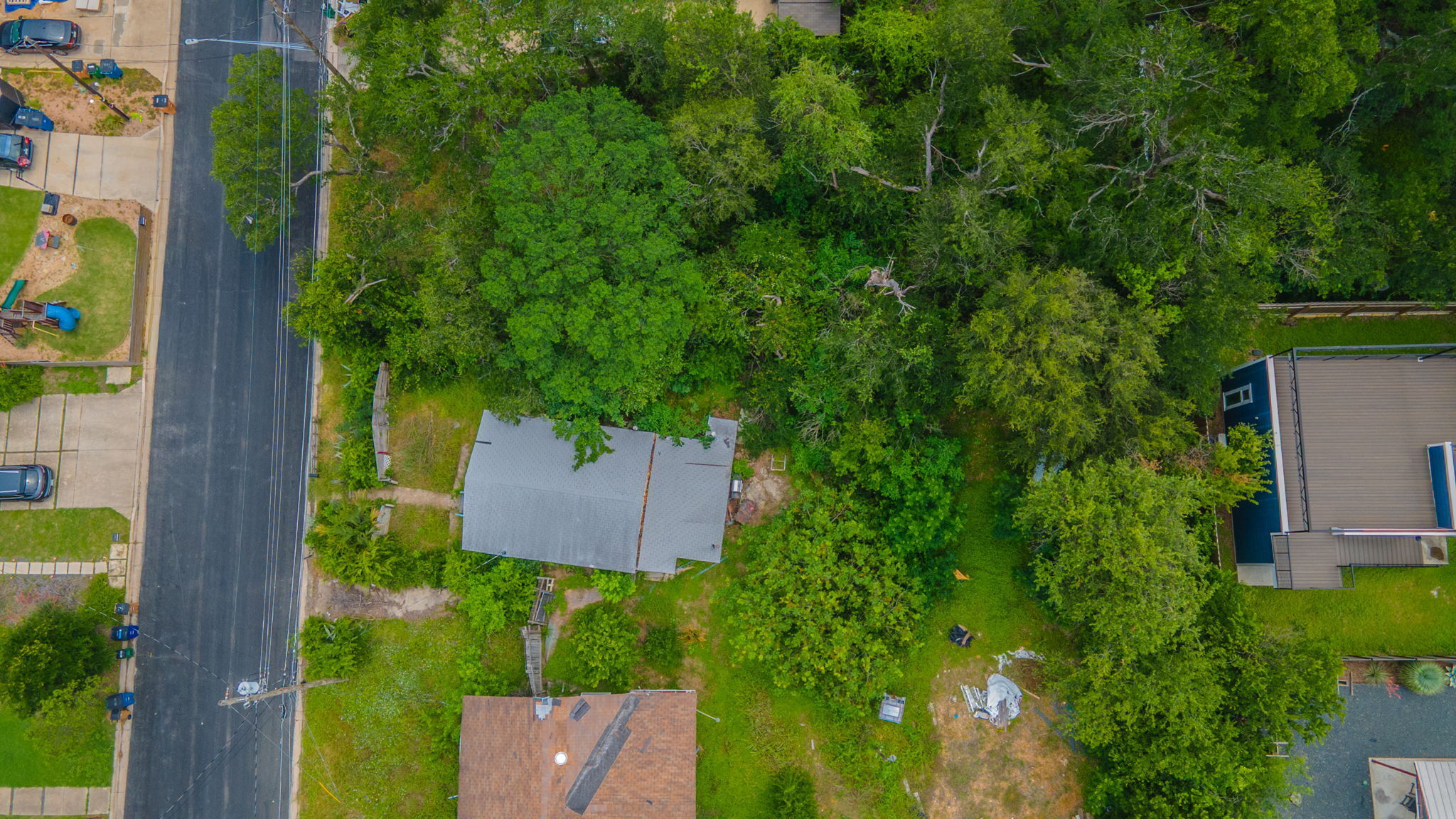 1408 Luna Street Austin, TX 78721 - Photo 3 of 5 An aerial perspective showcases the verdant tree canopy surrounding a residence and neighboring properties.