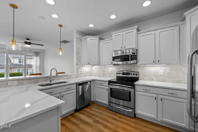 a kitchen with stainless steel appliances granite countertop a sink and stove top oven
