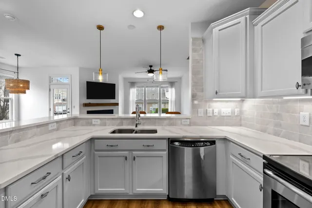 a kitchen with stainless steel appliances a sink a stove and a wooden floor