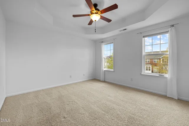 an empty room with windows and fan
