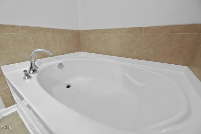 a bathroom with a white bath tub sitting next to shower