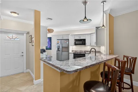 a kitchen with stainless steel appliances granite countertop a sink a stove and a refrigerator